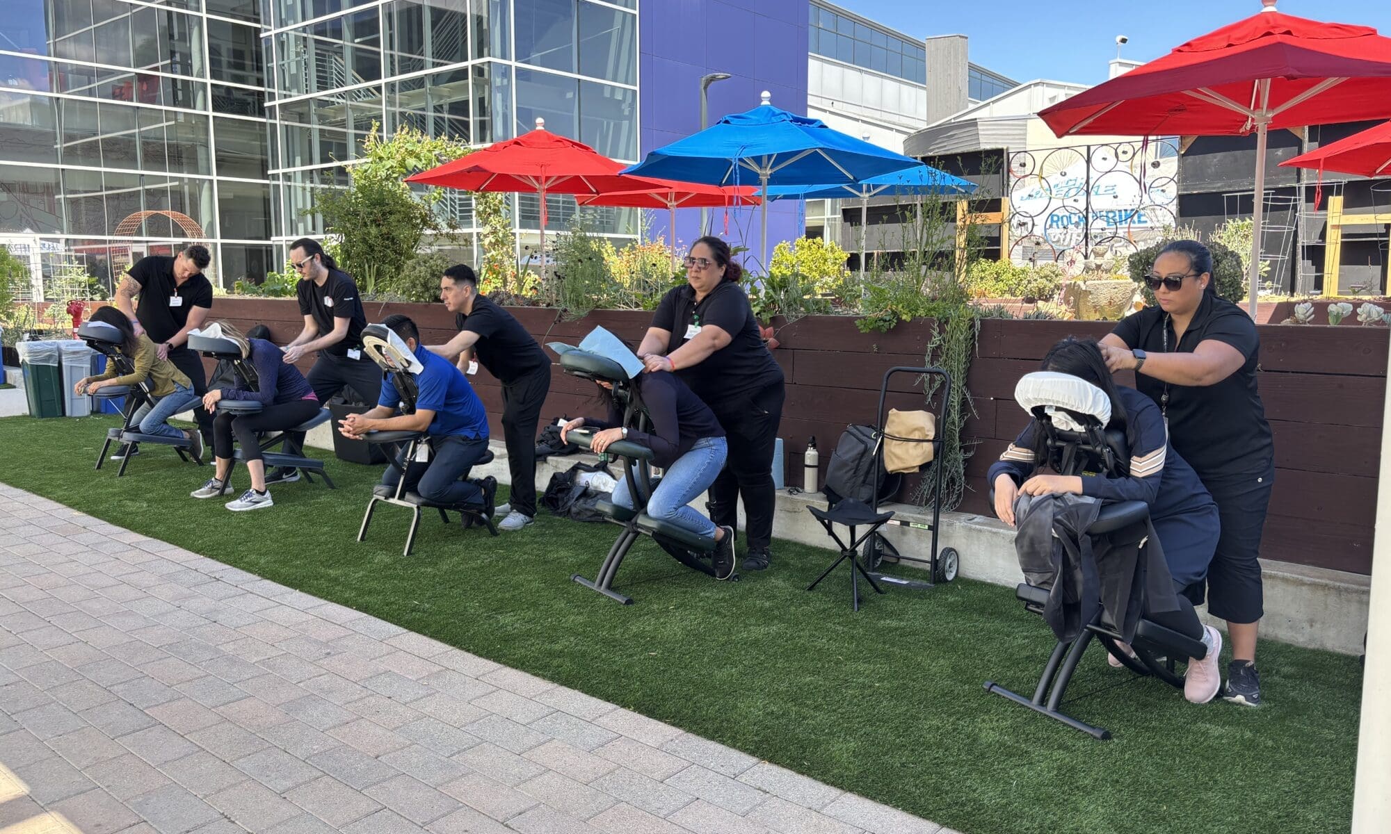 Team enjoying an onsite massage event to relieve lactic acid build-up and promote relaxation