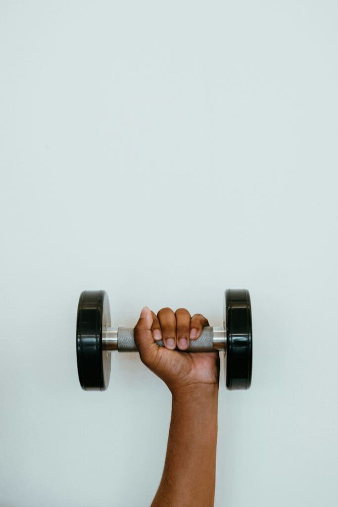 A woman's hand holding a dumbbell during exercise for health and fitness
